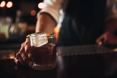 a person holding a glass of drink on a table at Los Angeles Athletic Club in Los Angeles