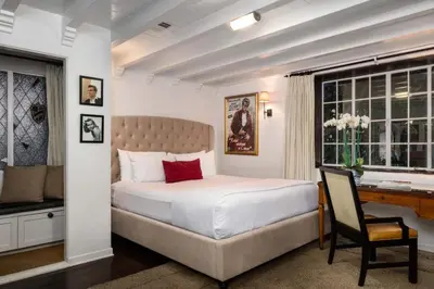 a bedroom with a bed and a desk and a chair at The Charlie West Hollywood in Los Angeles
