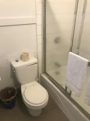 a white bathroom with a toilet and a shower at Hotel West Inn, Hollywood - LA in Los Angeles
