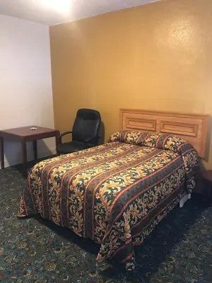 a hotel room with a bed and a chair at Hotel West Inn, Hollywood - LA in Los Angeles
