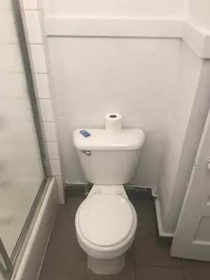 a bathroom with a toilet with a roll of toilet paper on it at Hotel West Inn, Hollywood - LA in Los Angeles