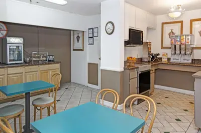 a kitchen with blue tables and chairs in a room at Howard Johnson by Wyndham Torrance in Torrance