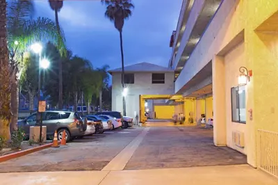 a parking lot with cars parked in front of a building at Howard Johnson by Wyndham Torrance in Torrance