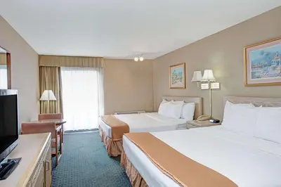 a hotel room with two beds and a flat screen tv at Howard Johnson by Wyndham Torrance in Torrance