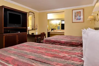 a hotel room with two beds and a flat screen tv at Americas Best Value Inn Pasadena in Pasadena