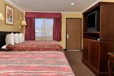 a hotel room with a bed and a flat screen tv at Americas Best Value Inn Pasadena in Pasadena