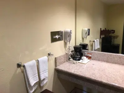a bathroom with a sink and a mirror and towels at Americas Best Value Inn Pasadena in Pasadena