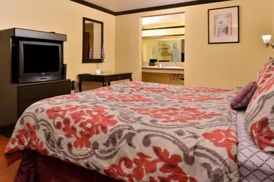 a hotel room with a bed and a flat screen tv at Americas Best Value Inn Pasadena in Pasadena