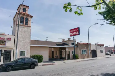 a car is parked in front of a motel at Mission Motel in Lynwood