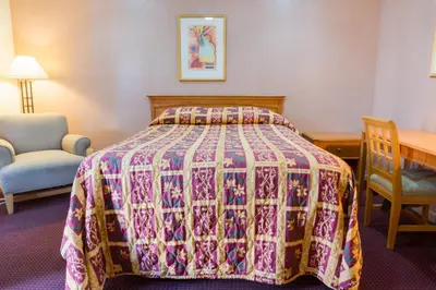 a bedroom with a bed with a quilt on it at Mission Motel in Lynwood