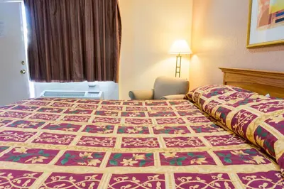 a hotel room with a bed with a quilt on it at Mission Motel in Lynwood