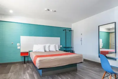 a bedroom with a bed and a blue wall at Solo Motel Broadway in Los Angeles