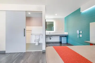 a bedroom with a bed and a bathroom with a sink at Solo Motel Broadway in Los Angeles