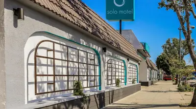 a building with windows on the side of a street at Solo Motel Broadway in Los Angeles
