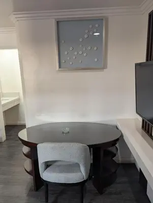 a dining room table with a chair and a television at Airport Motel - Inglewood in Inglewood
