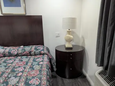 a bedroom with a bed and a lamp on a dresser at Airport Motel - Inglewood in Inglewood