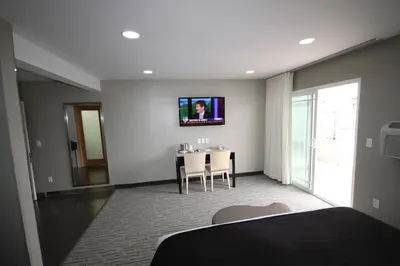 a bedroom with a table and a tv on the wall at Grandview Inn in Hermosa Beach