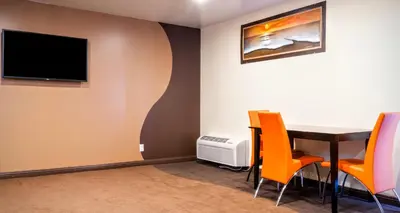 a dining room with a table and chairs and a tv at Redondo Pier Inn in Redondo Beach