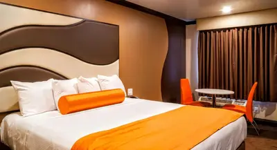 a bedroom with a large bed with an orange headboard at Redondo Pier Inn in Redondo Beach