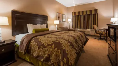 a hotel room with a large bed and a desk at Best Western Route 66 Glendora Inn in Glendora