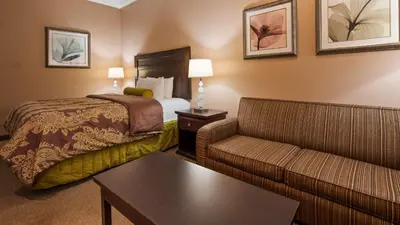 a hotel room with a bed and a couch at Best Western Route 66 Glendora Inn in Glendora
