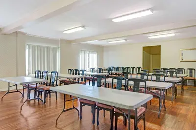 an empty room with tables and chairs at Travelodge by Wyndham Lynwood in Lynwood