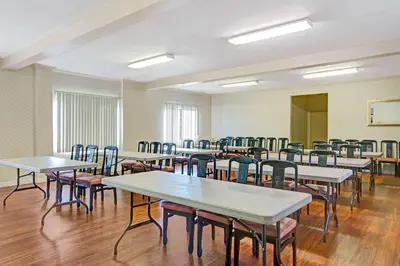 an empty room with tables and chairs at Travelodge by Wyndham Lynwood in Lynwood