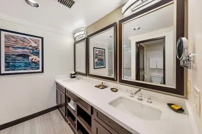 a bathroom with a sink and two mirrors at Best Western Plus Redondo Beach Inn in Redondo Beach