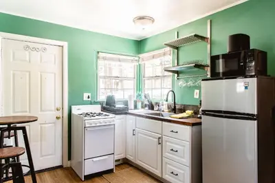a kitchen with green walls and a white refrigerator at Lakewood Cabins in Big Bear Lake