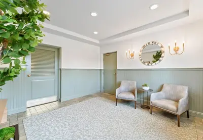 a hallway with two chairs and a table and a mirror at Inn at Playa del Rey in Los Angeles