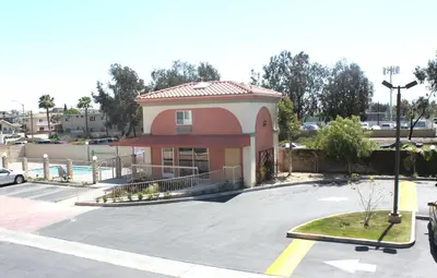 a small building in a parking lot with a parking lot at Crystal Inn Suites & Spas in Inglewood