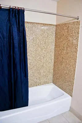 a bathroom with a shower with a blue shower curtain at Crystal Inn Suites & Spas in Inglewood