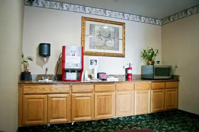 a kitchen with a counter with a microwave and a refrigerator at Crystal Inn Suites & Spas in Inglewood