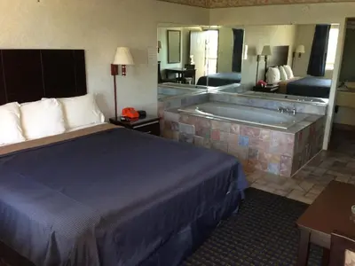 a hotel room with a bed and a bath tub at Del Amo Inn in Torrance