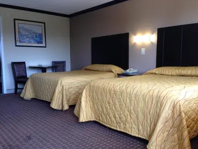 a hotel room with two beds and a table at Del Amo Inn in Torrance