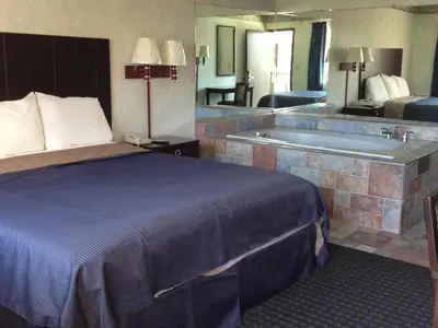 a hotel room with a bed and a bath tub at Del Amo Inn in Torrance