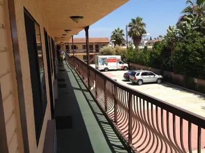 a balcony of a building with a car parked in a parking lot at Del Amo Inn in Torrance