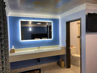 a bathroom with a sink and a mirror at Golden West Manor Motel in Los Angeles