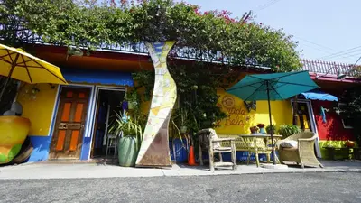 a restaurant with tables and umbrellas in front of it at Villa Brasil Motel in Los Angeles