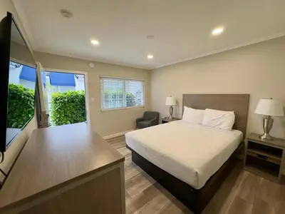 a bedroom with a bed and a desk and a window at Ocean Park Inn in Los Angeles