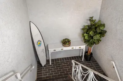 a room with a surfboard and a table with a plant at Ocean Park Inn in Los Angeles