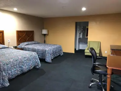 a hotel room with two beds and a desk and a chair at Los Angeles Inn & Suites - LAX in Los Angeles