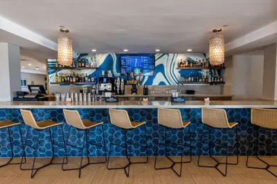 a bar in a restaurant with a blue at Redondo Beach Hotel, Tapestry Collection by Hilton in Redondo Beach