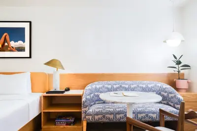 a hotel room with a bed and a chair and a table at Short Stories Hotel Near The Grove in Los Angeles