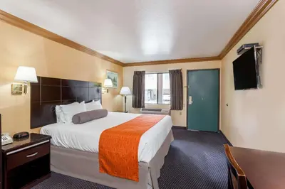 a hotel room with a bed and a television at Howard Johnson by Wyndham Norco in Norco
