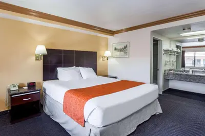 a hotel room with a large bed and a bathroom at Howard Johnson by Wyndham Norco in Norco