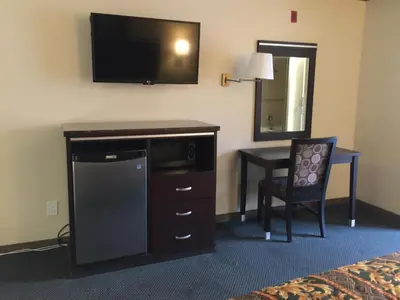 a hotel room with a television and a desk with a chair at Mountain Inn in Ontario