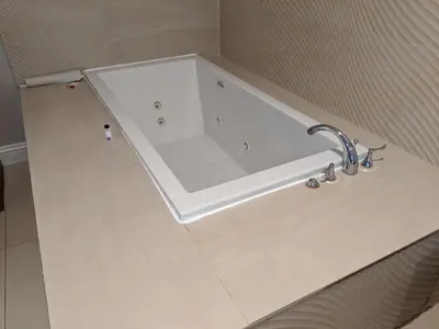 a bathroom with a bath tub with a sink at Ramada by Wyndham Redondo Beach in Redondo Beach