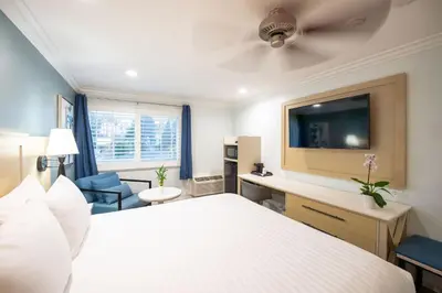 a hotel room with a bed and a flat screen tv at Ramada by Wyndham Redondo Beach in Redondo Beach