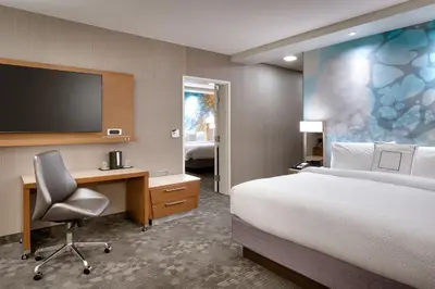 a hotel room with a bed and a desk and a tv at Courtyard by Marriott Los Angeles LAX/Hawthorne in Hawthorne